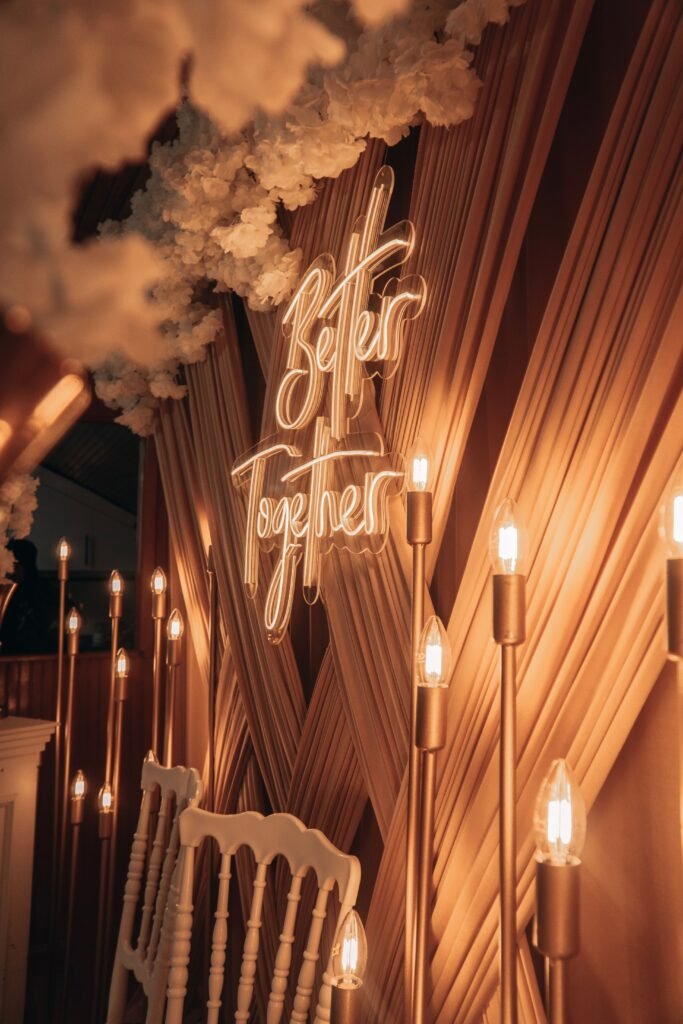 Elegant wedding backdrop featuring a 'Better Together' neon sign and warm lighting for a romantic ambiance.