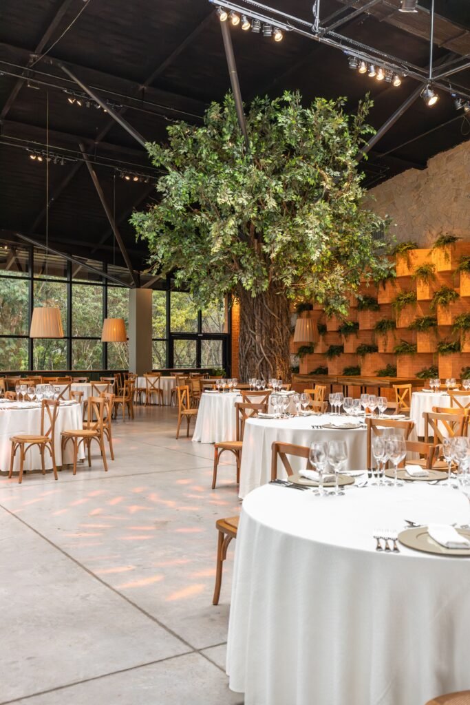 Stylish dining area adorned with an indoor tree and modern decor for luxurious events.